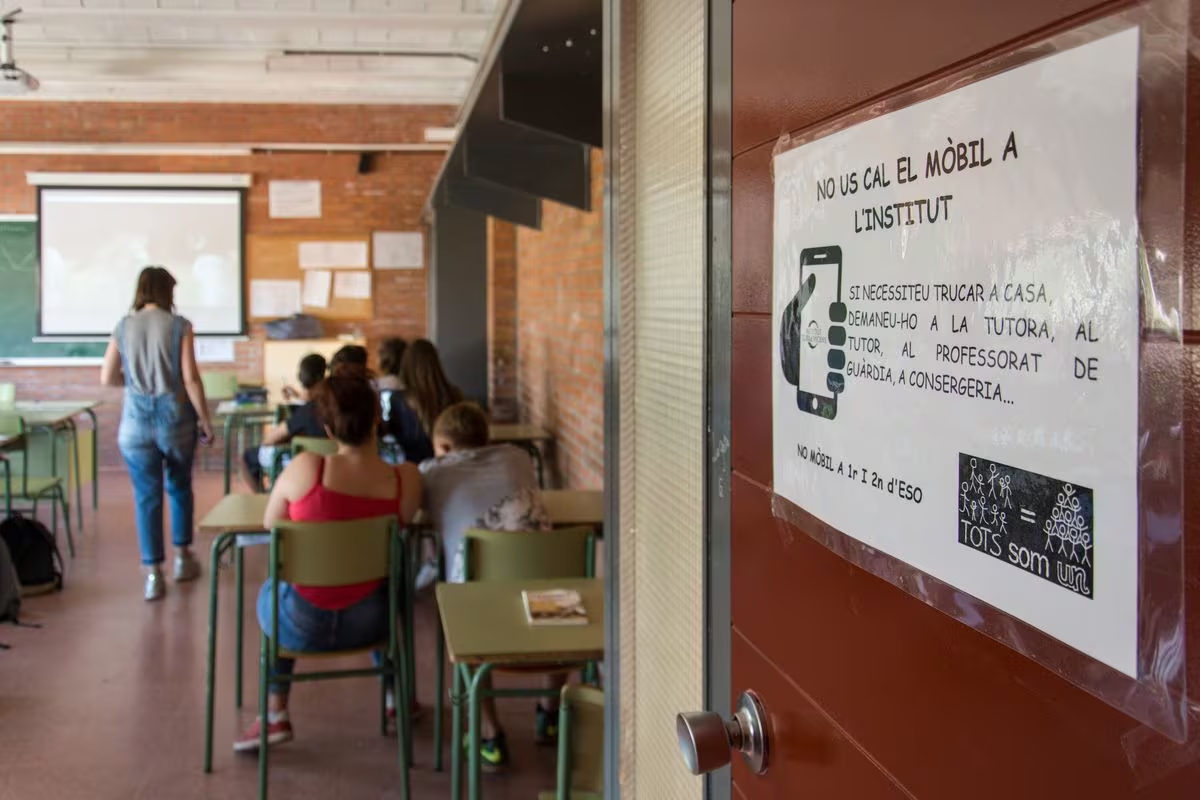 Cartel en catalán que avisa de la prohibición del teléfono móvil en el instituto